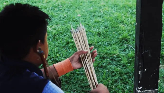 A man is counting arrows for an archery game presenting the Shillong teer game. 